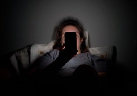 Un adolescente navega desde su teléfono móvil antes de dormirse.