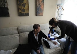 Un enfermo recibiendo asistencia sanitaria en su domicilio.
