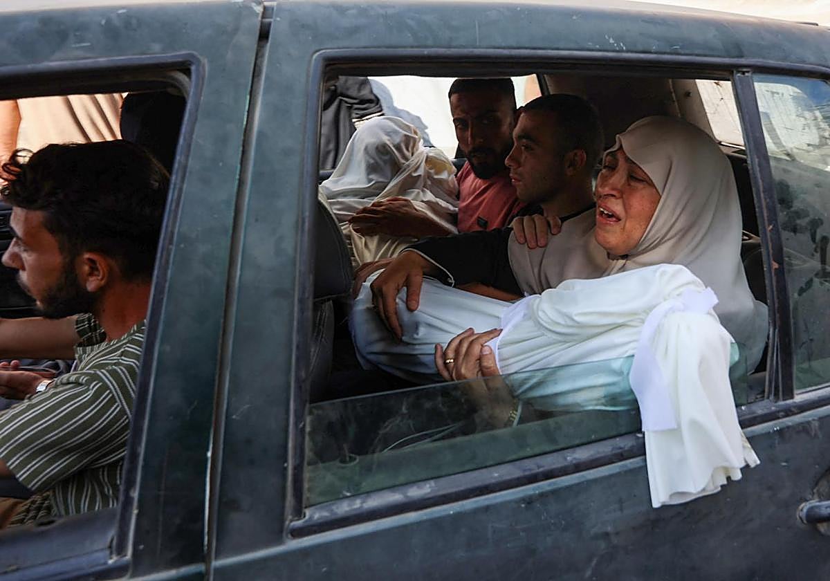 Una mujer sostiene el cadáver de un familiar muerto en un bombardeo de Israel en Gaza City.