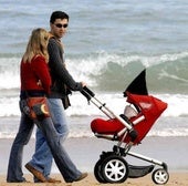 Una pareja pasea por la playa con su hijo.