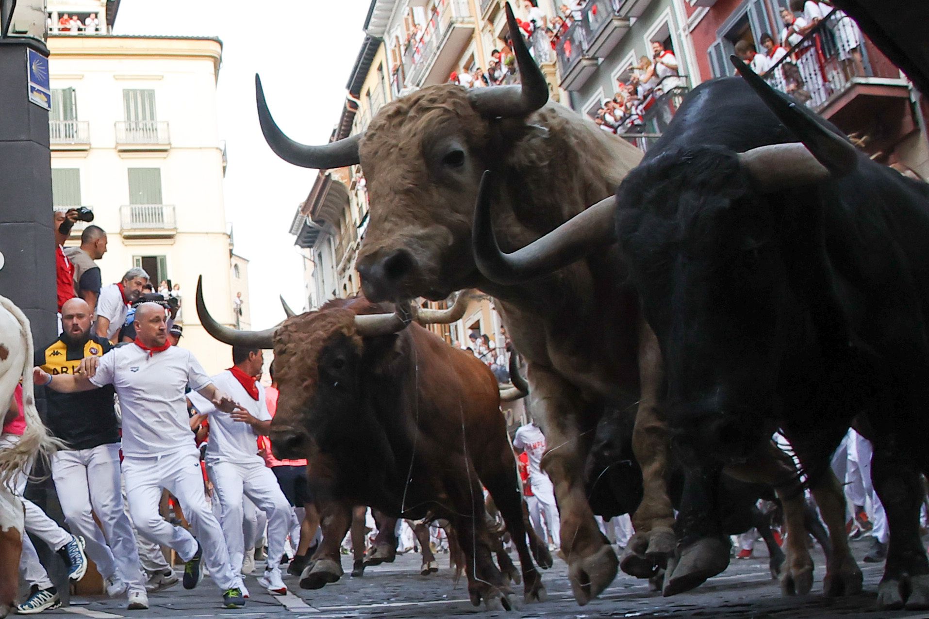 Los toros de la ganadería Jandilla persiguen a los mozos a su paso por la curva de Mercaderes durante el quinto encierro de los Sanfermines este viernes en Pamplona.