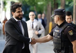El eurodiputado Alvise Pérez saluda este viernes a un policía en el Tribunal Supremo antes de declarar por presunta financiación irregular de su partido.