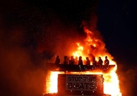 Arde una hoguera con muñecos de migrantes en una patera, en Moygashel.