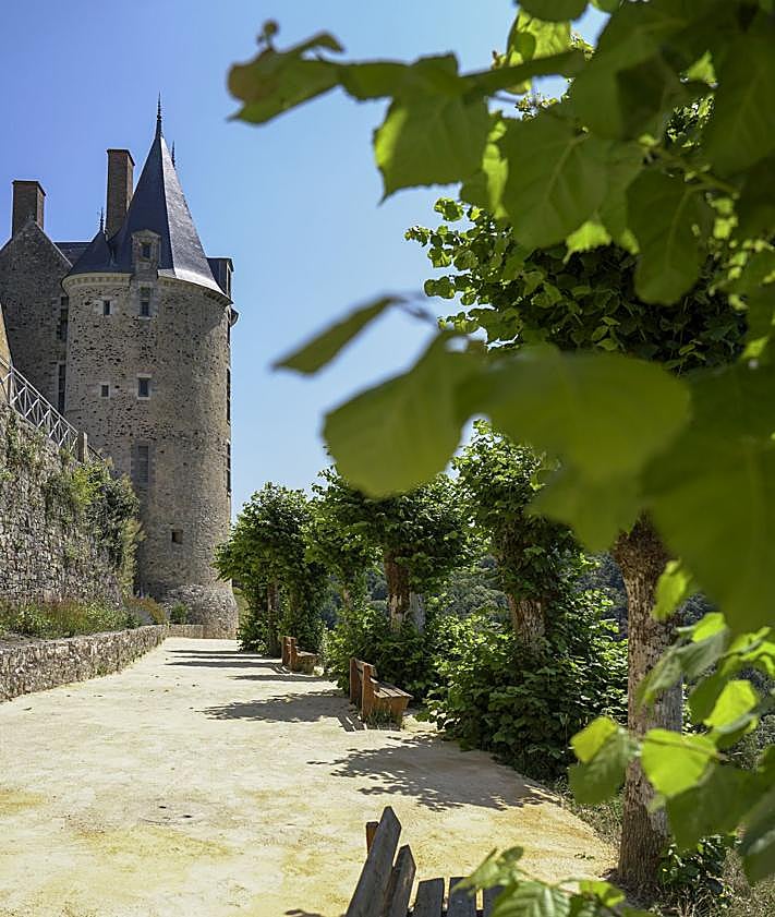 Imagen secundaria 2 - Arriba, detalle de un letrero con una figura de las cartas del tarot. A la izquierda, vistas del pueblo desde lo alto del castillo. A la derecha, la senda extramuros conocida como 'le promenade de la Poterne' que rodea el pueblo de Sainte Suzanne.