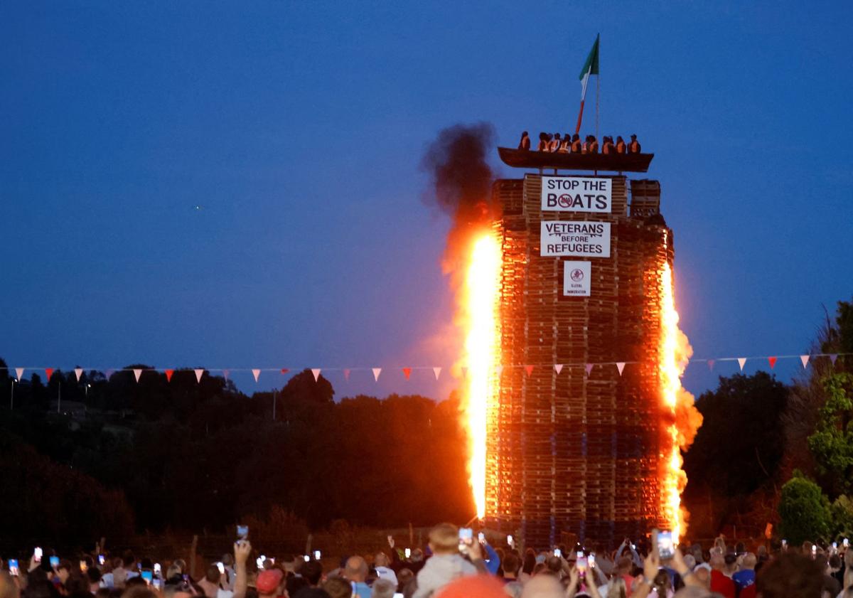 Imagen principal - Protestantes queman la figura de una patera de migrantes en Irlanda del Norte
