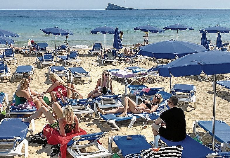 Un grupo de bañistas toma el sol en la playa de Levante.