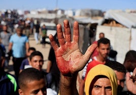 Desplazados cerca de un centro de distribución de ayuda en Gaza.