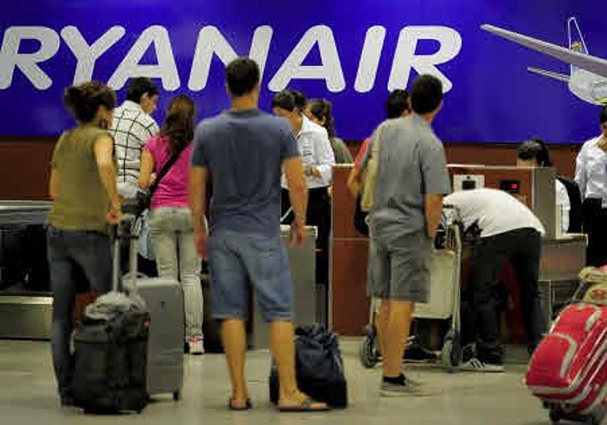 Pasajeros facturando su maleta antes de un vuelo.