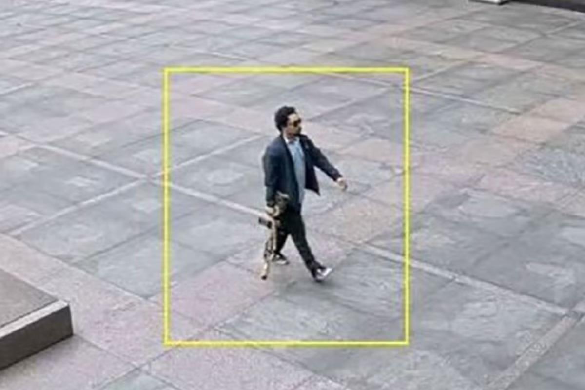 Shane Tamura, con el fusil en la mano, se dirige al vestíbulo del rascacielos.