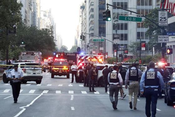 Policías, bomberos y sanitarios aguardan frente al 345 de Park Avenue.