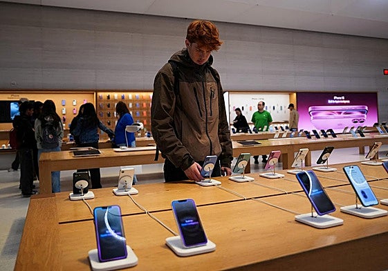 Un cliente mira varios modelos del iPhone de Apple en una tienda de Nueva York.
