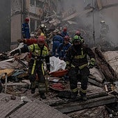 Los bomberos rescatan un cuerpo de entre los escombros de un edificio residencial destruido por un misil este jueves en Kiev.