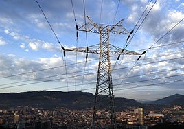 Una torre de transporte de energía con la ciudad de Bilbao de fondo