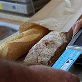Un cliente paga una barra de pan con tarjeta.
