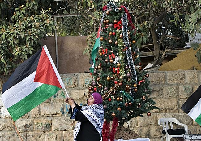 Una mujer palestina frente a un árbol de Navidad en Jerusalén.
