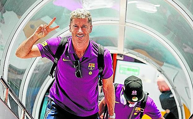 Lewandoswi hace la señal de victoria al subir al avión en Corea.