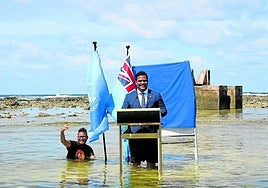 El ministro de Justicia de Tuvalu, Simon Cofe, dio su conferencia en la COP26 desde un atril en una zona inundada del país.