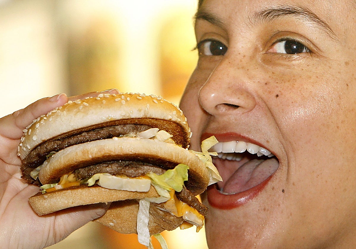 Una mujer se dispone a comer una hamburguesa doble.
