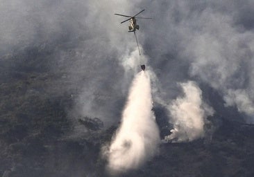 Un helicóptero trabaja en las labores de extinción del incendio que desde ayer afecta a la Sierra de la Plata