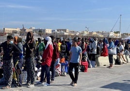 Decenas de migrantes esperan en la isla italiana de Lampedusa.