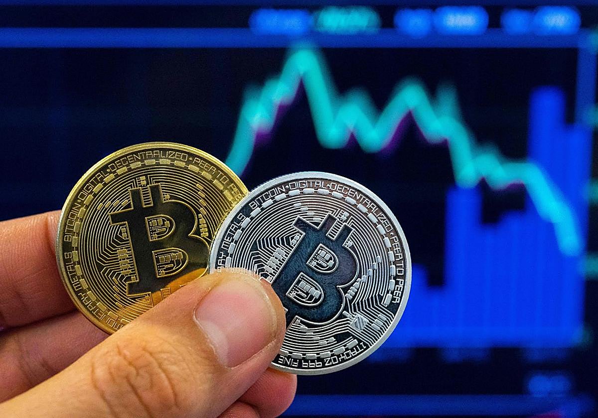 Una persona con la representación virtual de un bitcóin