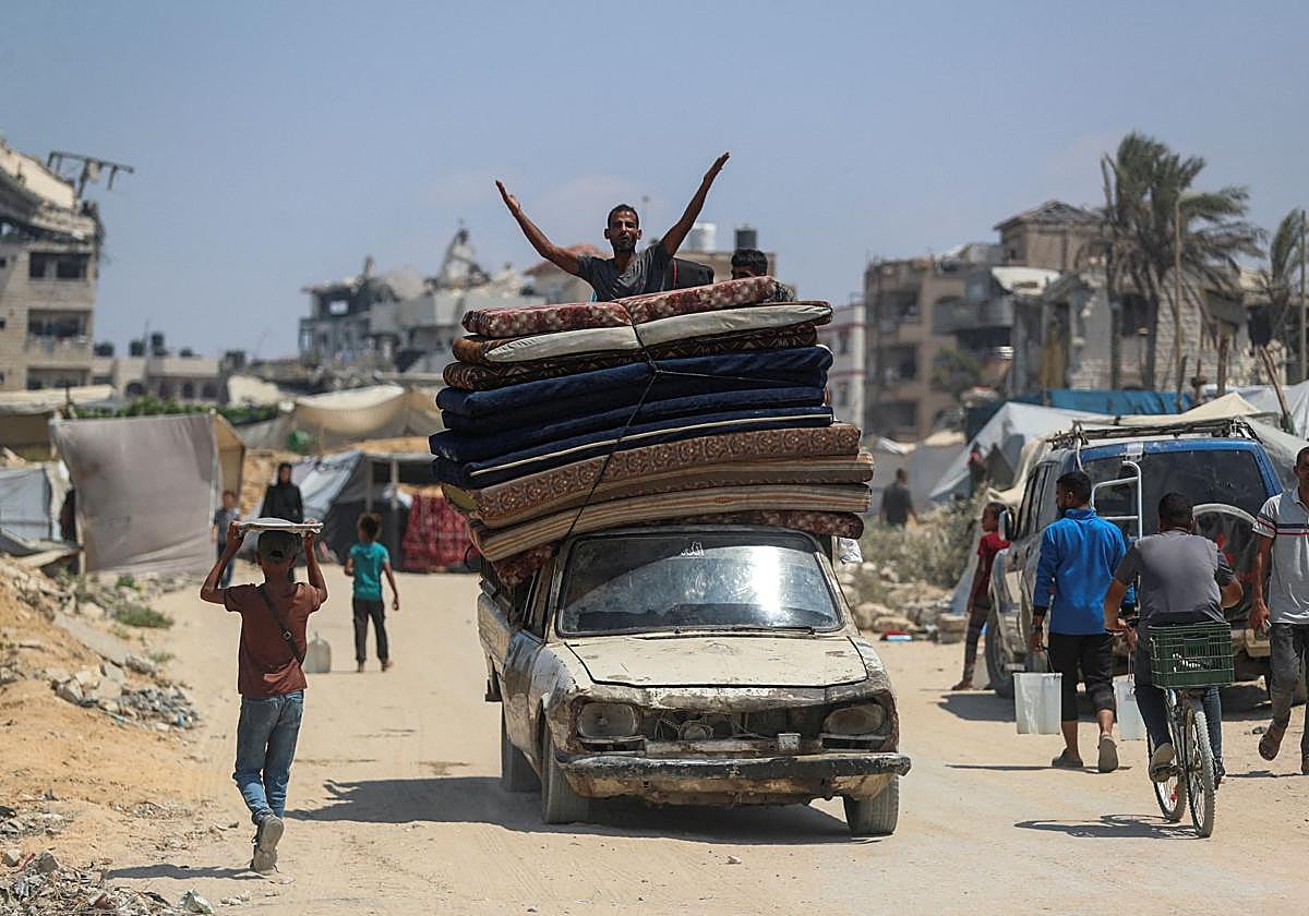 Un hombre huye del norte de Gaza sobre un vehículo cargado con sus enseres.