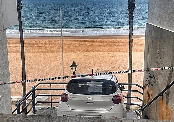 Un coche en unas escaleras de acceso a la playa en Rota (Málaga).