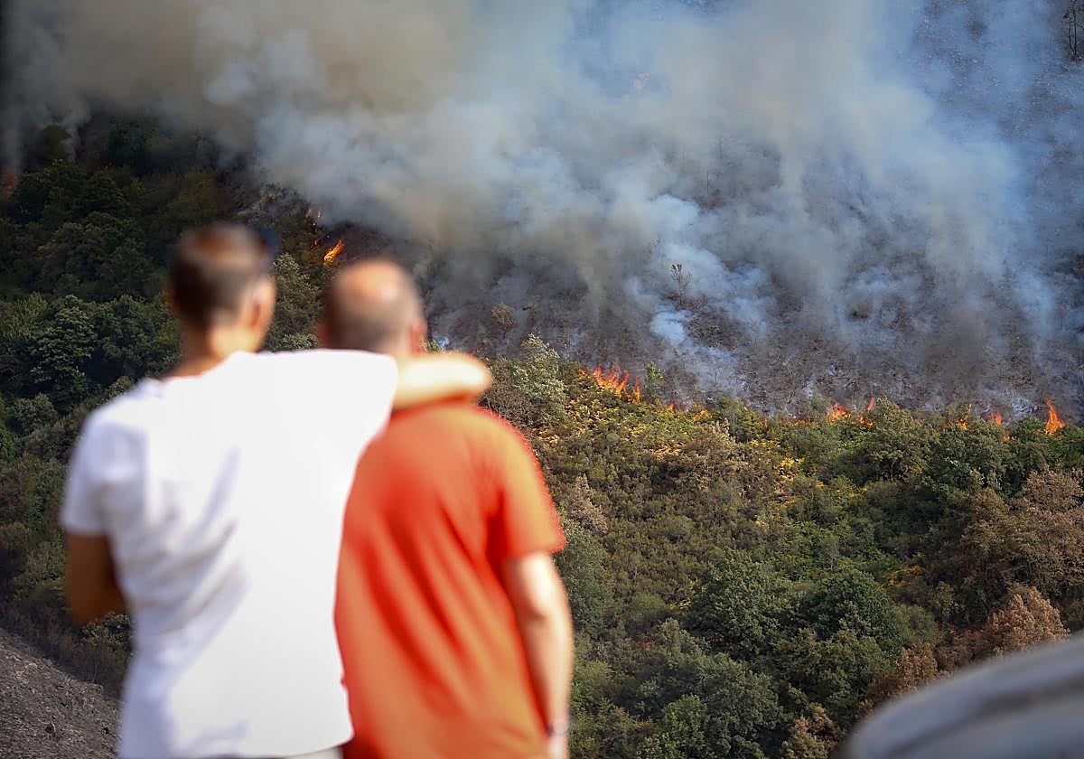 Varias personas observan el incendio, en la sierra de O Courel.
