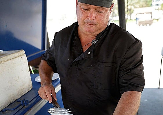 Catalín montando el espeto de sardinas.