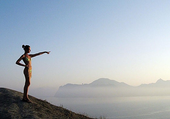 Turista señala con el índice hacia el Mar Negro desde una colina de Koktebel, en la península de Crimea.