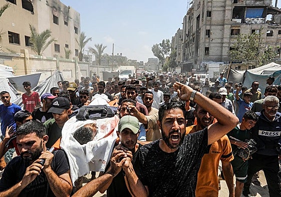 Palestinos transportan el cadáver de un periodista asesinado en el ataque israelí contra el hospital Al Nasser de Jan Younis.