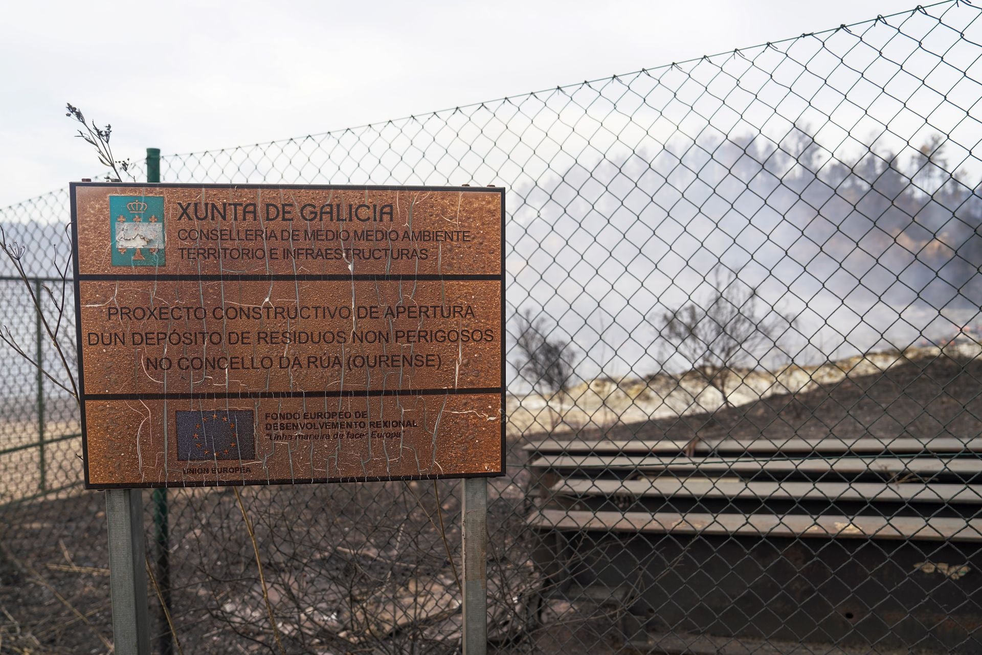 Imagen principal - Arriba, cartel a la entrada abierta al vertedero. A la izquierda, María José Luengo, vecina del pueblo, con la mascarilla que usa cada vez que sale a la calle. A la derecha Javier Quintas, técnico farmacéutico despachando mascarillas.