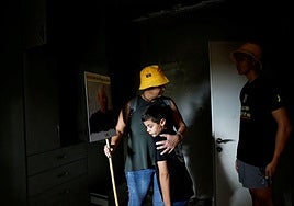 Familiares de Ilan Weiss, víctima del ataque del 7 de octubre, se reúnen en su casa incendiada durante una ceremonia en el primer año de los atentados.