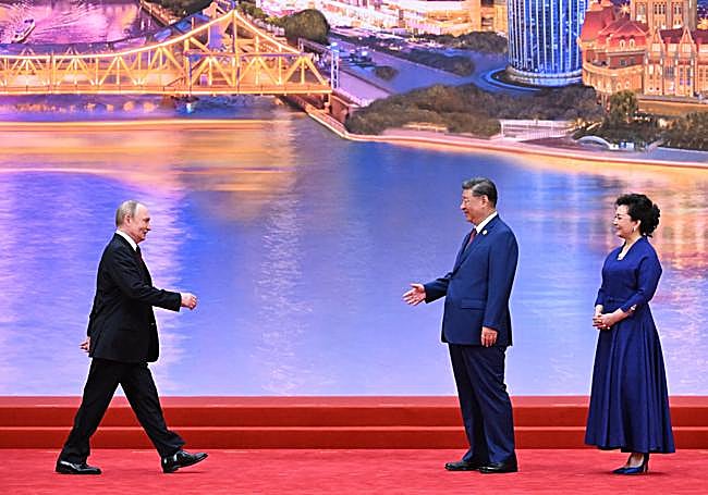 Putin se dirige a saludar a Xi y a su esposa, Peng Liyuan.