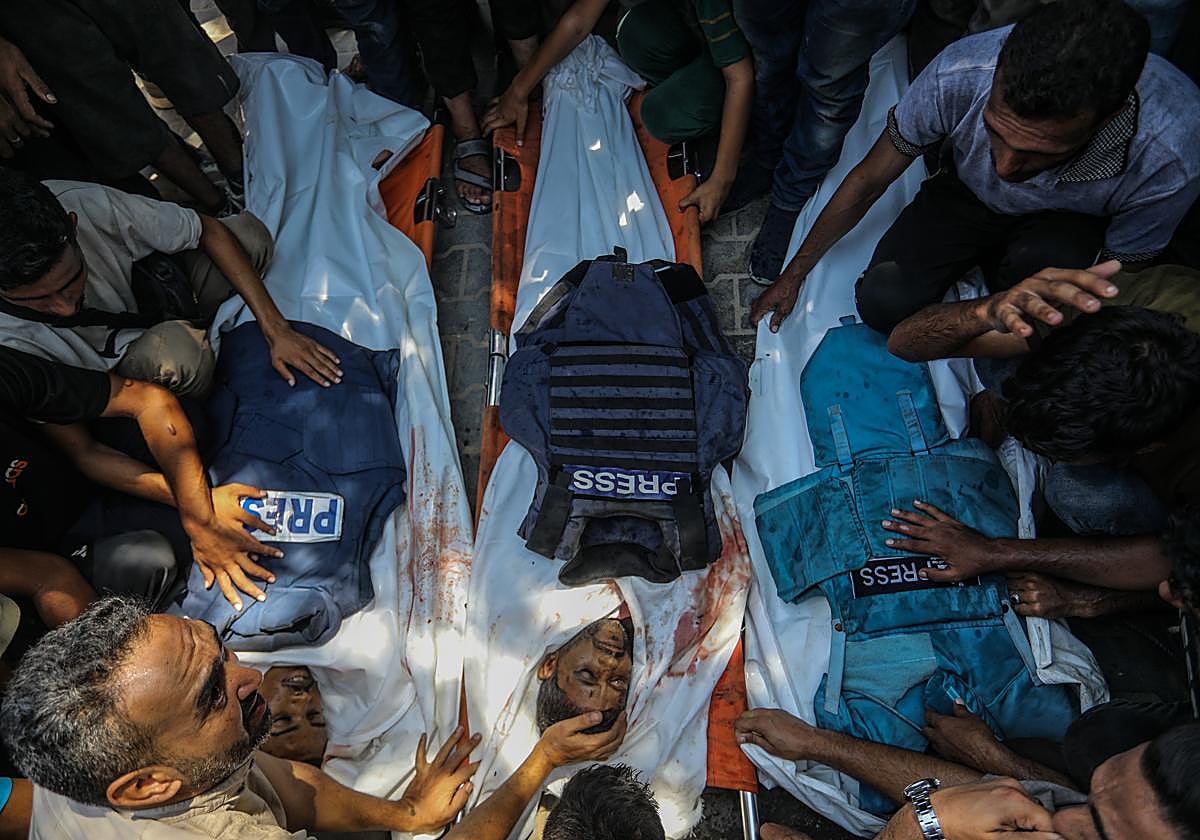 Palestinos velan los cuerpos de los periodistas fallecidos en el ataque del 25 de agosto.