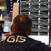 Analista observa los gráficos de las acciones en Wall Street.