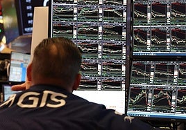 Analista observa los gráficos de las acciones en Wall Street.
