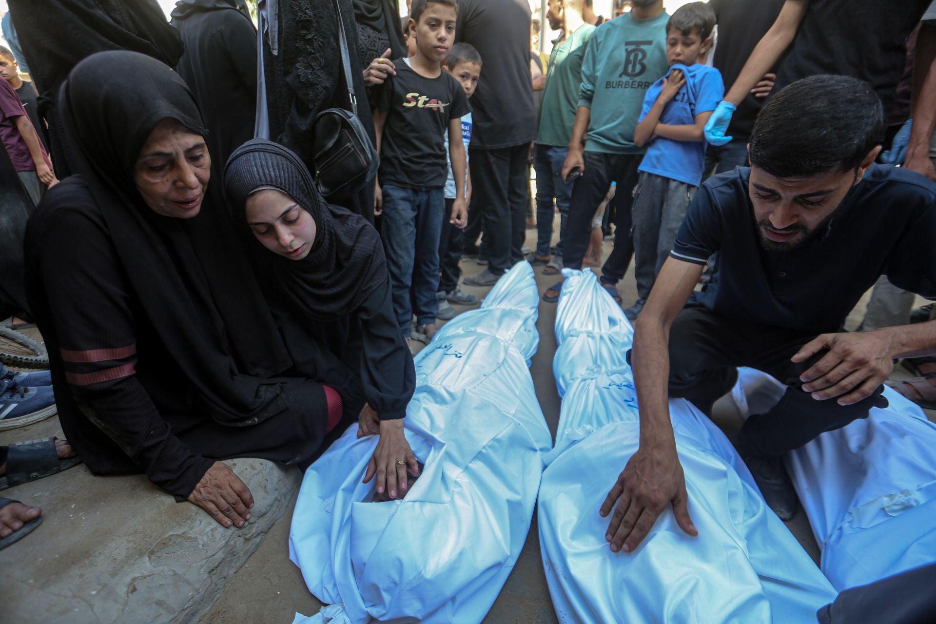 Palestinos velan a sus familiares fallecidos en los ataques israelíes de la pasada madrugada.