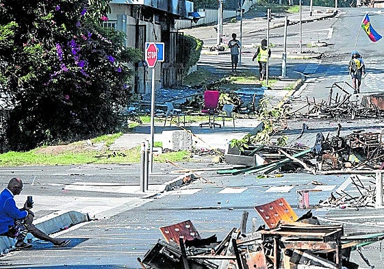 Una calle bloqueada por escombros y objets quemados tras los disturbios en Numea, territorio francés de Nueva Caledonia, en mayo de 2024