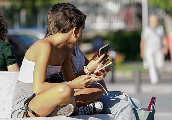 Dos adolescentes en la puerta de un instituto.