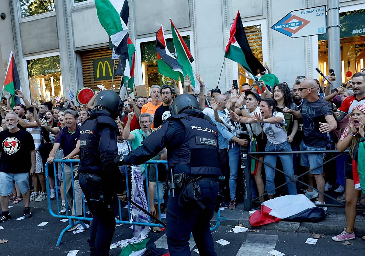 Policías intentan frenar a los manifestantes.