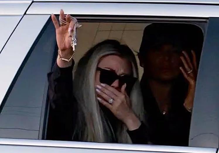 Erika Kirk muestra un crucifijo a los seguidores de su marido que esperaban el paso del cortejo fúnebre.