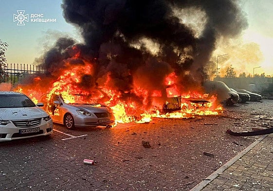Vehículos en llamas al ser atacado un edificio cerca de Kiev.
