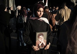 Una joven sostiene el retrato de Hasán Nasrala en Beirut.