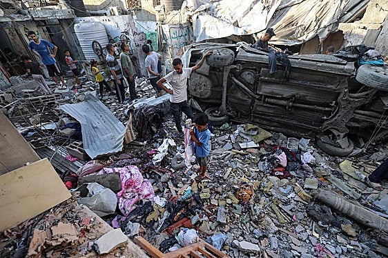 Una familia gazatí entre los restos de una casa destruida en un bombardeo israelí.