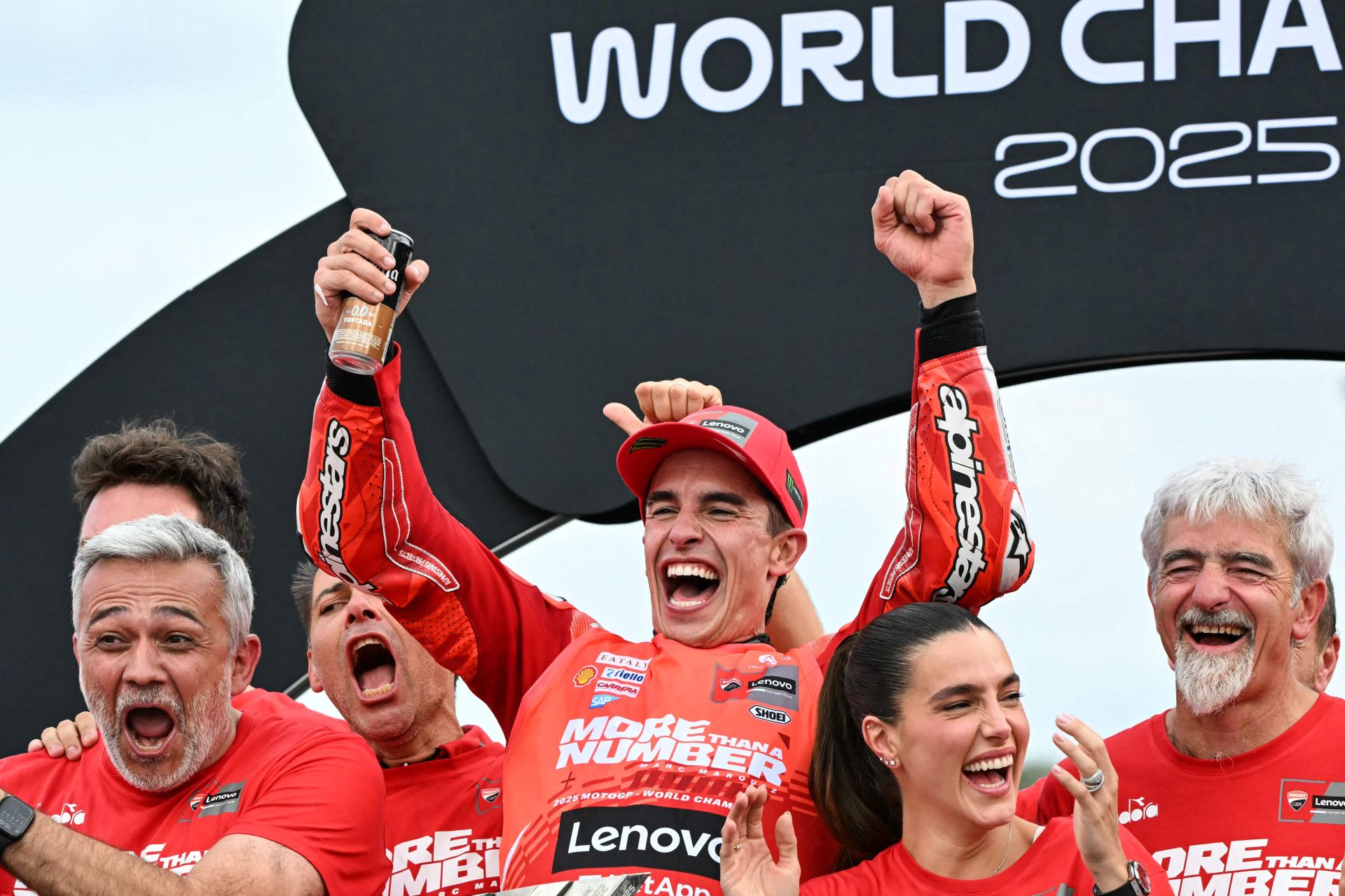Marc Márquez celebra el título de campeón del mundo de MotoGP junto a los integrantes de su equipo y su pareja.