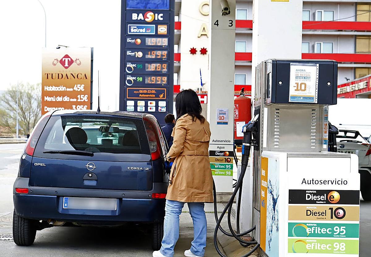 Una mujer echa gasolina al coche.