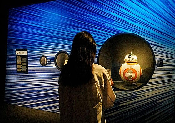 Una joven observa la marioneta del androide BB-8 utilizada en 'Star Wars: El despertar de la fuerza'.