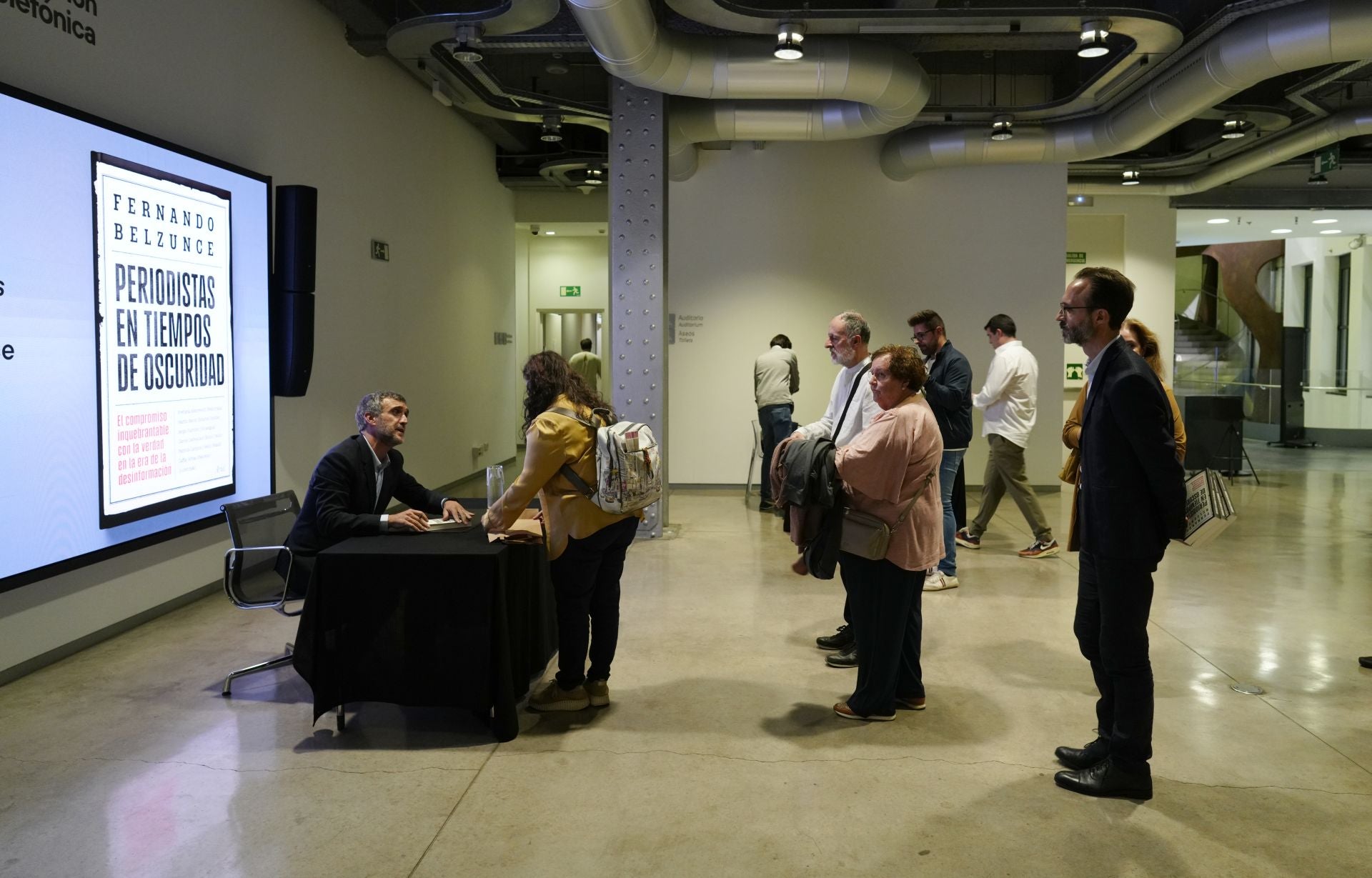 El director general editorial de Vocento firma ejemplares a los asistentes. 