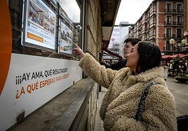 Una pareja de jóvenes, buscando piso en una agencia inmobiliaria.